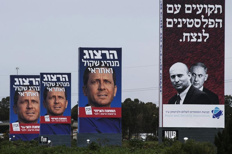 © Reuters. Cartazes de campanha mostram Isaac Herzog (esquerda) em Tel Aviv