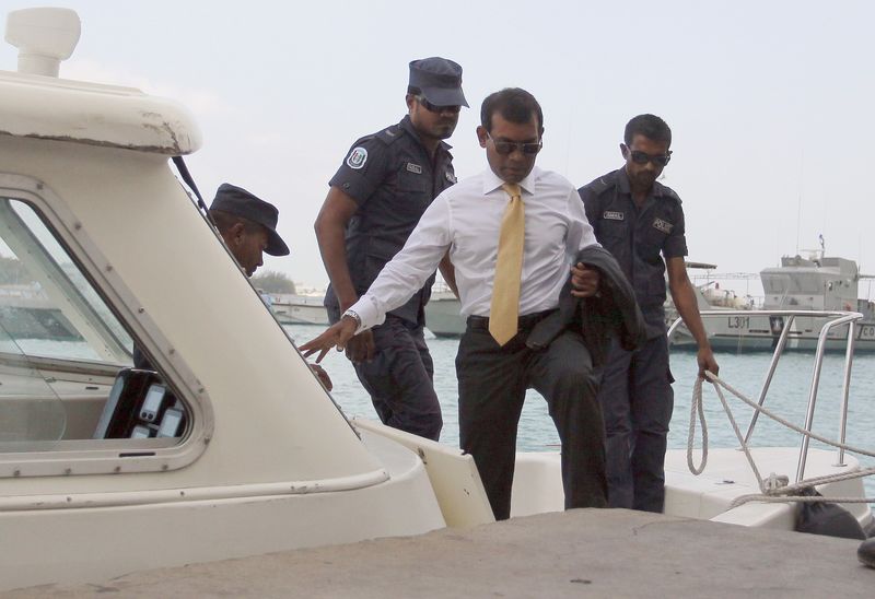 © Reuters. Nasheed arrives at Mal'e City with police officers