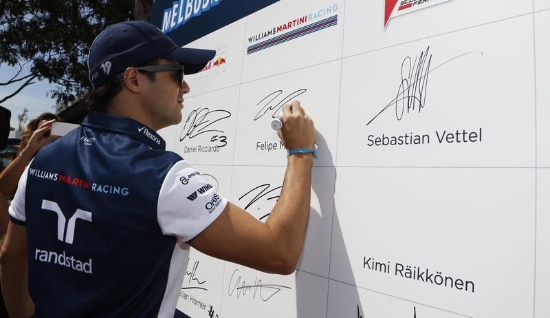 © Reuters. Williams Formula One driver Felipe Massa of Brazil signs the wall as he arrives for the Australian F1 Grand Prix at the Albert Park circuit in Melbourne