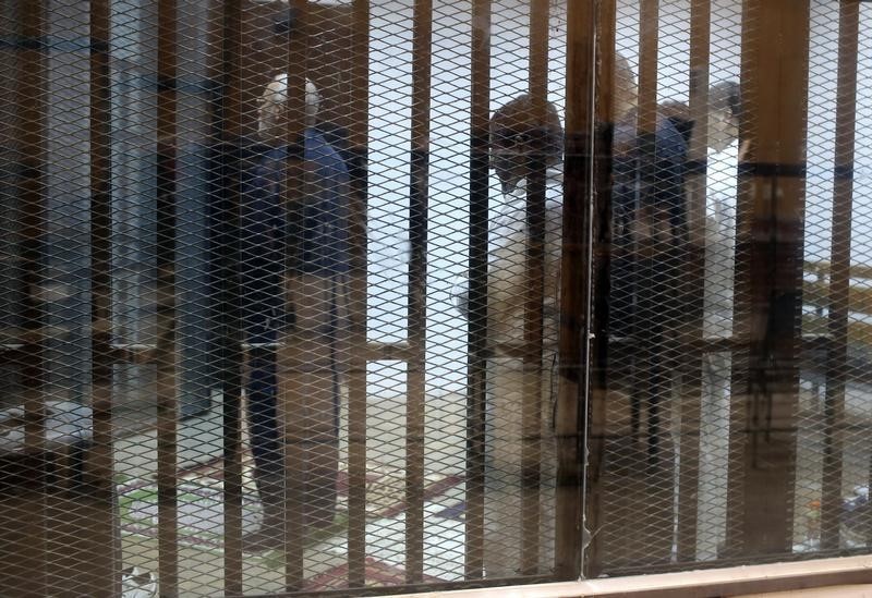 © Reuters. Muslim Brotherhood's Supreme Guide Mohamed Badie prays behind bars with other Muslim Brotherhood members at a court in the outskirts of Cairo