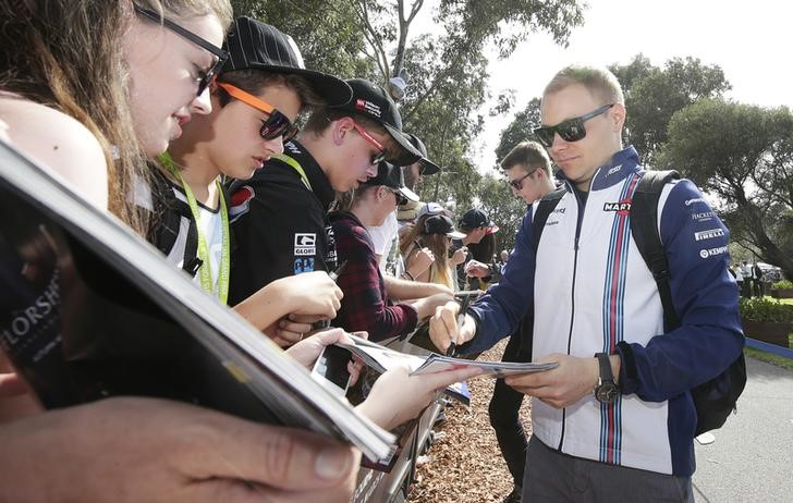 © Reuters. Williams Formula One driver Valtteri Bottas of Finland signs autographs as he arrives for the Australian F1 Grand Prix at the Albert Park circuit in Melbourne