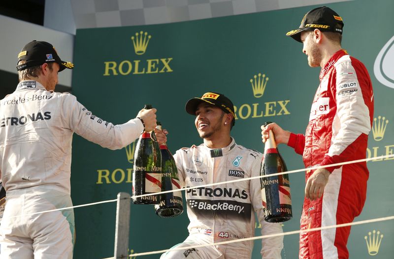 © Reuters. Second placed Rosberg, race winner Hamilton and third placed Vettel celebrate on the podium after the Australian F1 Grand Prix in Melbourne