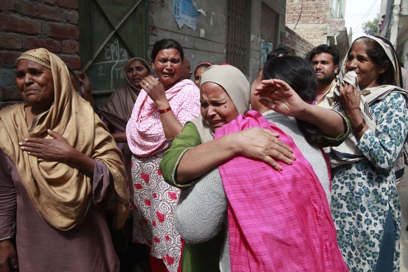 © Reuters. Women mourn the death of their relative who was killed in a suicide attack on a church in Lahore