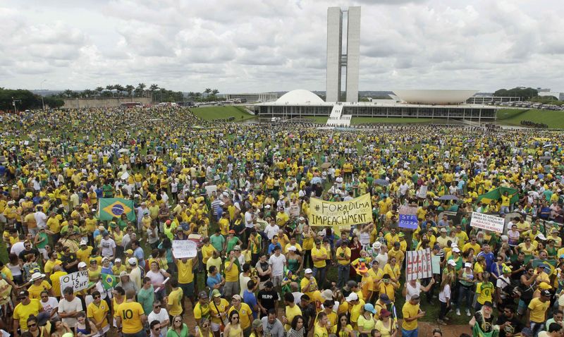 © Reuters. Manifestantes muestran carteles durante una protesta contra la presidenta brasileña Dilma Rousseff en frente del Congreso brasileño en Brasilia