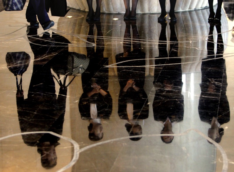 © Reuters. File photo of a porter carrying luggage past a group of reception staff that are reflected in the floor as they stand in the foyer of the five-star rated Sofitel Hotel in Beijing