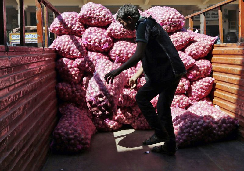 © Reuters. Man loads onion sacks in a supply truck at a wholesale market in Ahmedabad