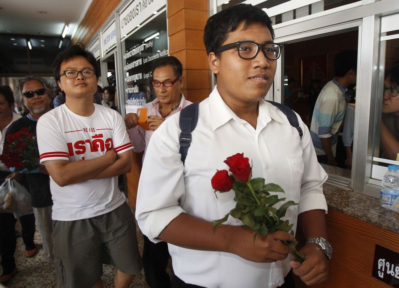 © Reuters. Arnon, a 30-year-old rights lawyer, and Sirawith, 24, a student, leaves a police station for the military court in Bangkok