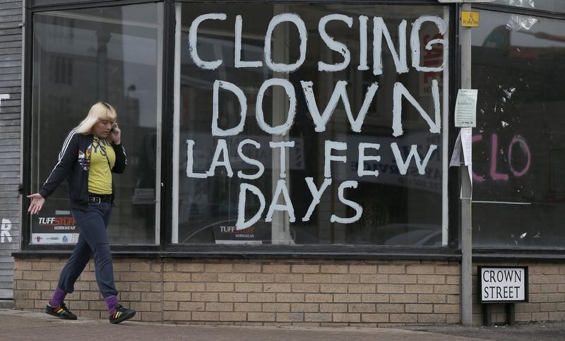 © Reuters. A woman walks past a closed shop in Hanley, Stoke on Trent