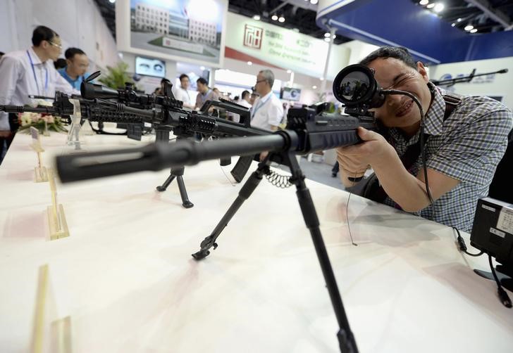 © Reuters. A visitor looks through a collimation sighting device of a machine gun during the China International Exhibition on Police Equipment, in Beijing