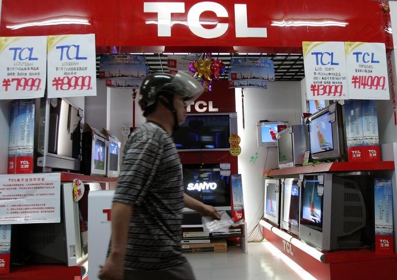 © Reuters. Chinese man walks past TCL television store in Shanghai.