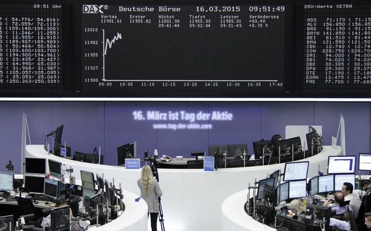 © Reuters. Traders work at their screens in front of the German share price index DAX board at the stock exchange in Frankfurt 