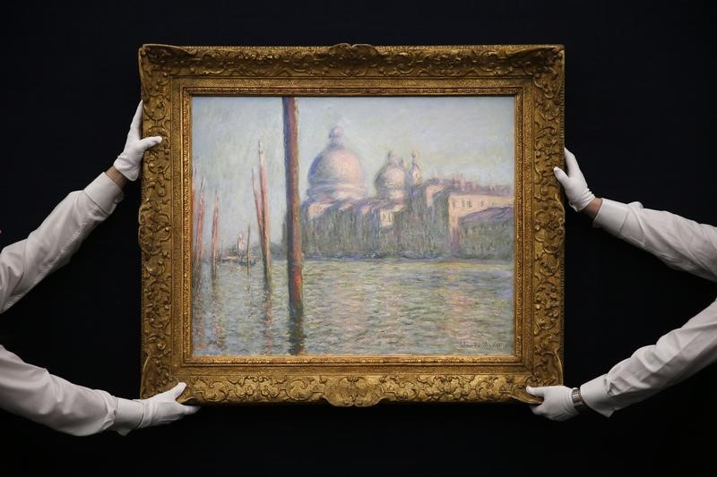 © Reuters. Sotheby's employees pose with "Le Grand Canal", painted by Claude Monet, at Sotheby's preview in London