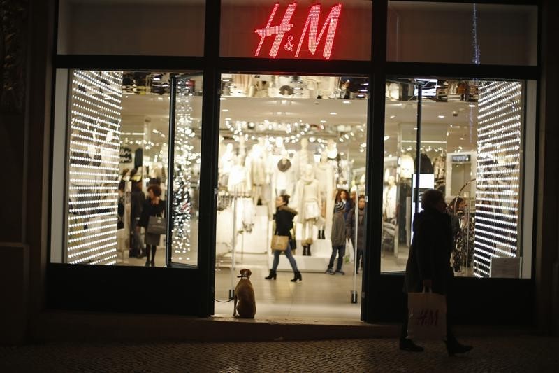 © Reuters. A dog waits its owner at a H&M store in Lisbon