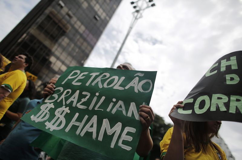 © Reuters. Demonstrator holds a placard during a protest against Brazil's President Dilma Rousseff at Paulista Avenue in Sao Paulo