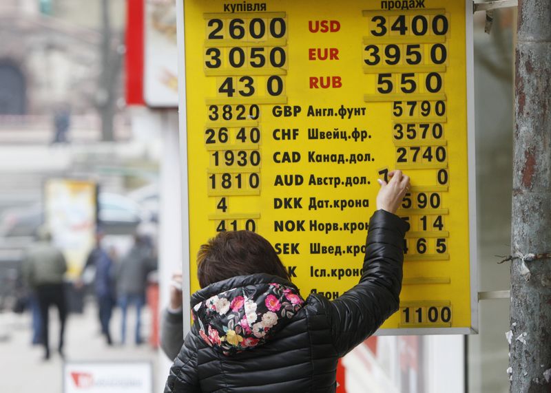 © Reuters. Woman changes exchange rate on a display board at a currency exchange office in Kiev