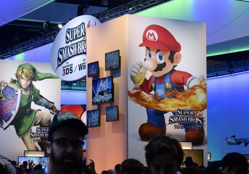 © Reuters. Attendees walk past Nintendo Co.'s Super Smash Bros. signage at the 2014 Electronic Entertainment Expo, known as E3, in Los Angeles