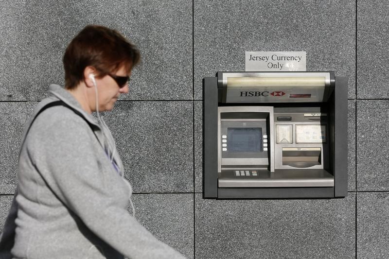 © Reuters. A woman walks past an HSBC cash machine in St Helier, Jersey