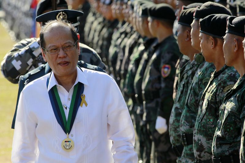 © Reuters. President Aquino walks past troops during the 29th PSG anniversary in Manila