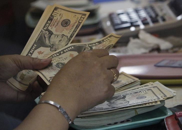 © Reuters. Mulher conta notas de dólar em casa de câmbio