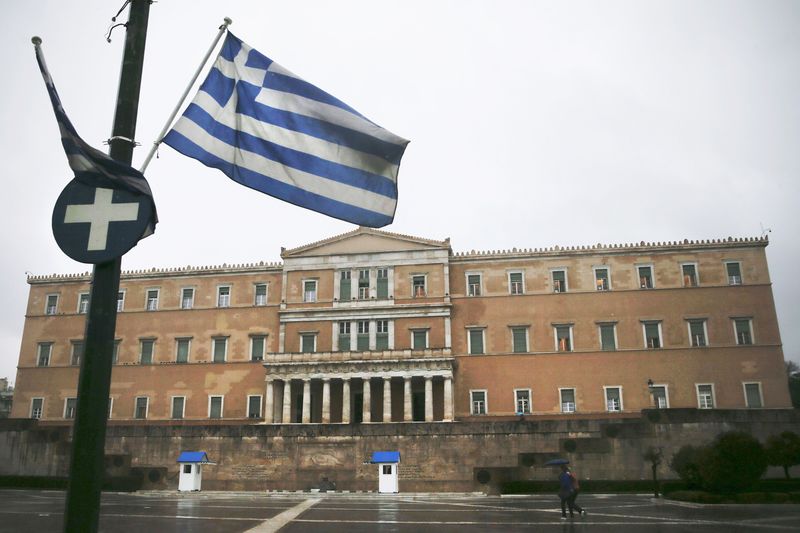 © Reuters. A Greek national flag flutters in front of the parliament building during heavy rainfall in Athens