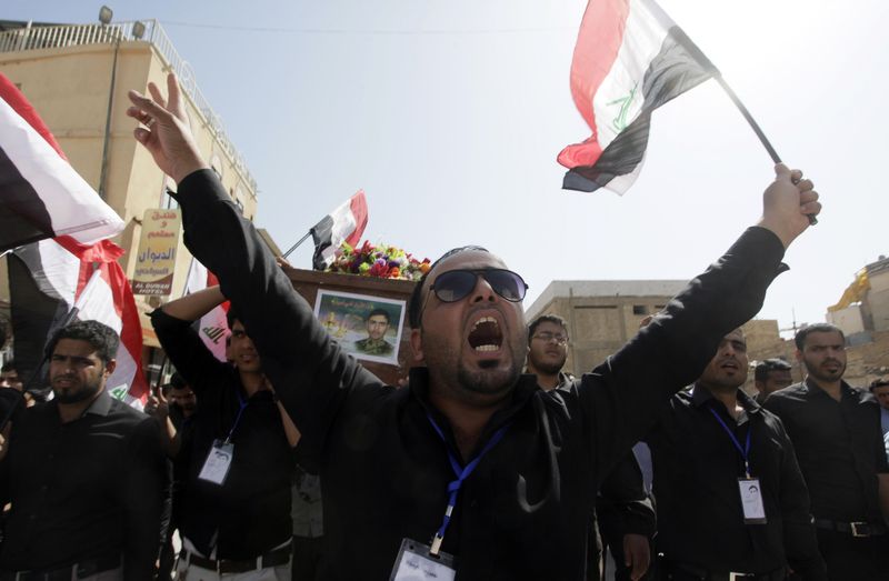 © Reuters. Populares reagem durante funeral em Najaf