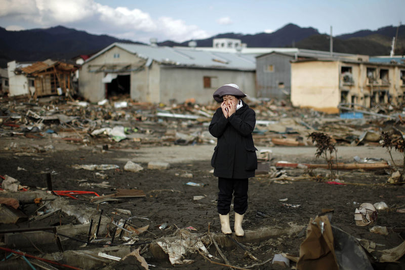 © Reuters. Mulher reage ao ver destroços de sua casa após tsunami