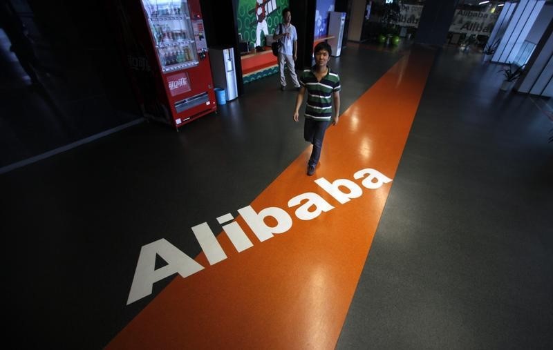 © Reuters. Employee walks pass a logo of Alibaba during a media tour organised by government officials at its headquarters on the outskirts of Hangzhou