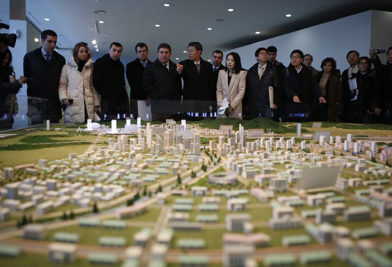 © Reuters. File photo shows officials from the G20 Seoul Conference looking at miniature models of the Kaesong Industrial Complex