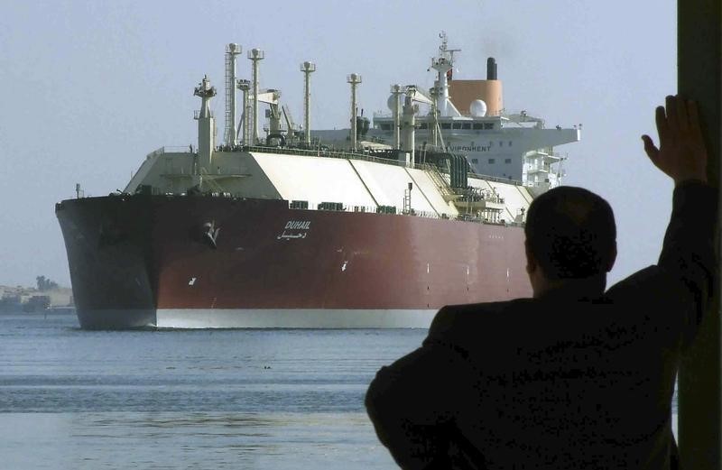 © Reuters. Мужчина смотрит на крупнейший в мире СПГ-танкер DUHAIL, когда он проходит по Суэцкому каналу