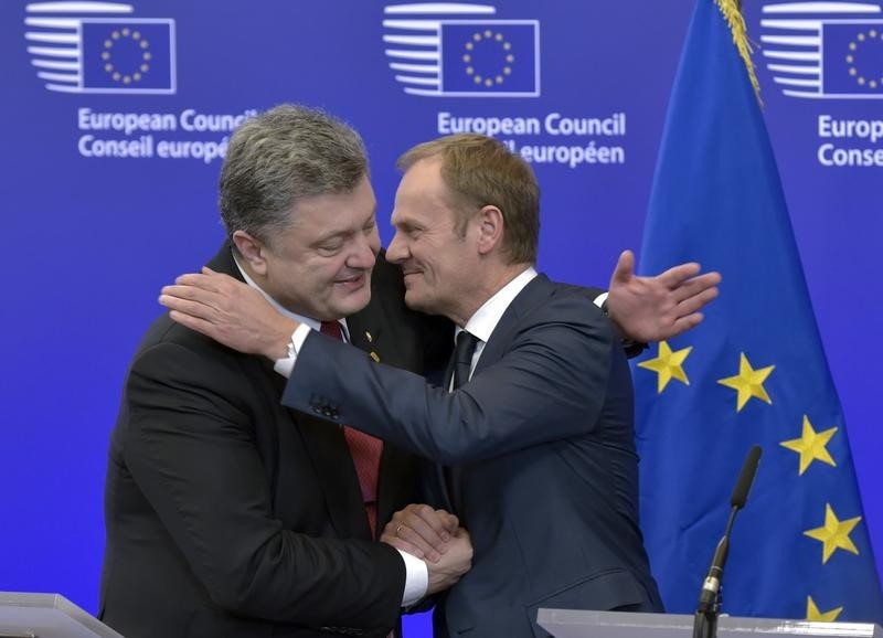 © Reuters. Il presidente ucraino Petro Poroshenko abbraccia il presidente del Consiglio europeo Donald Tusk