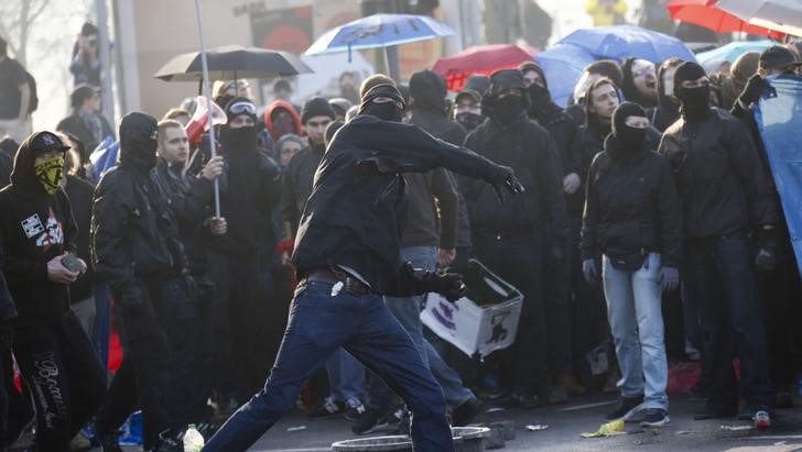 © Reuters. Manifestante joga pedras em policiais em frente a sede do BCE, em Frankfurt