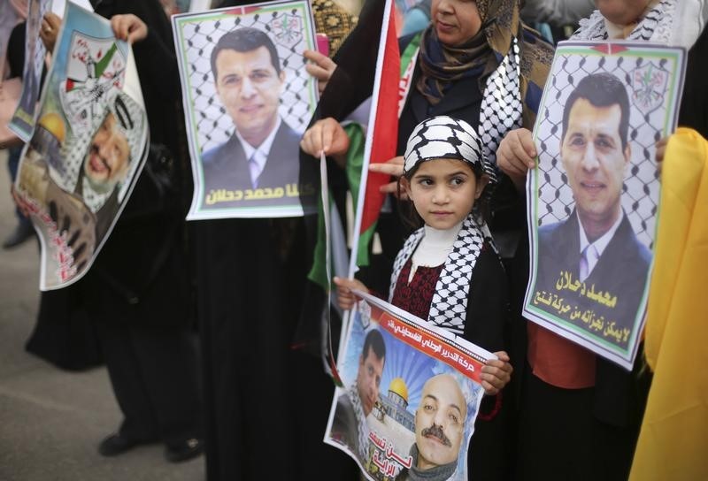 © Reuters. Palestinian supporters of former head of Fatah in Gaza, Mohammed Dahlan, hold posters during a protest against Palestinian President Mahmoud Abbas in Gaza City