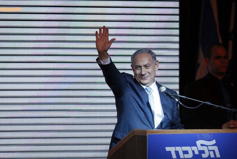 © Reuters. Israeli Prime Minister Netanyahu gestures to supporters at party headquarters in Tel Aviv