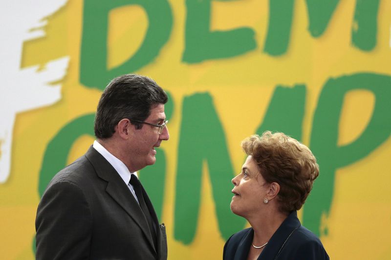 © Reuters. Ministro da Fazenda, Joaquim Levy, fala com a presidente Dilma Rousseff durante cerimônia no Palácio do Planalto em Brasília
