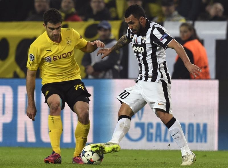 © Reuters. Papastathopoulos of Borussia Dortmund challenges Tevez of Juventus during their Champions League round of 16 second leg soccer match in Dortmund