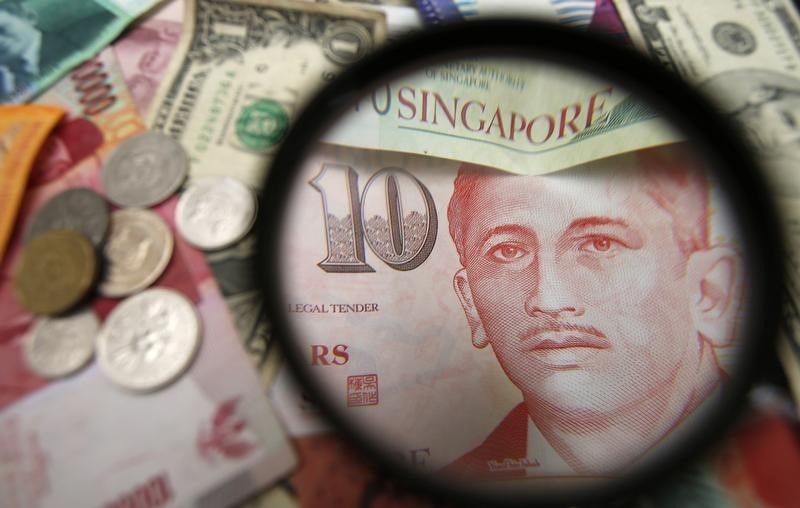 © Reuters. Photo illustration of bank notes and coins of various currencies including the Singapore dollar.