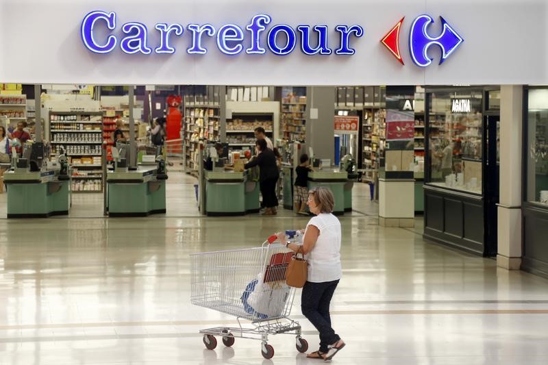 © Reuters. A customer pushes a shopping trolley as she arrives at the Carrefour's Bercy hypermarket in Charenton Le Pont, near Paris