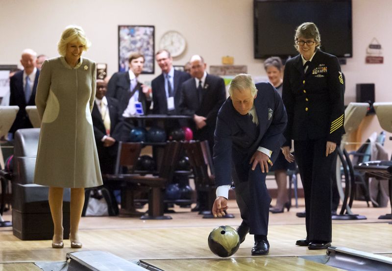 © Reuters. Britain's Prince Charles throws a bowling ball as he and his wife Camilla pay a visit to the Armed Forces Retirement Home in Washington