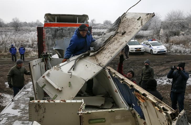 © Reuters. Trabalhadores locais transportam destroços do voo MH17 na Ucrânia
