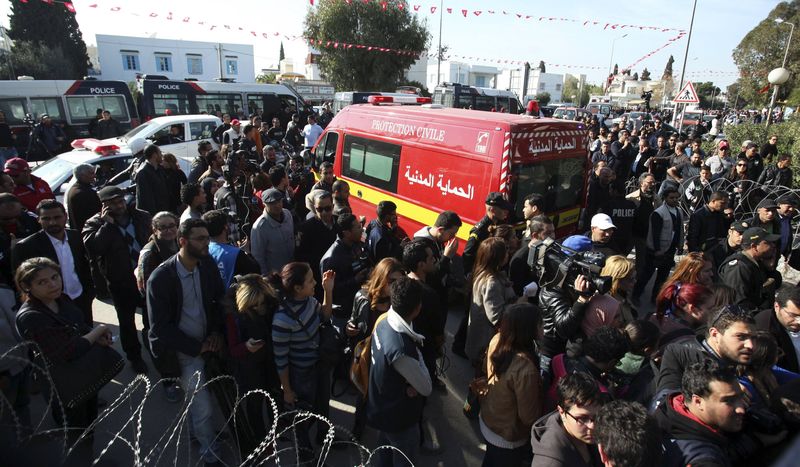 © Reuters. Pessoas cercam ambulância que transportava vítimas de ataque na Tunísia
