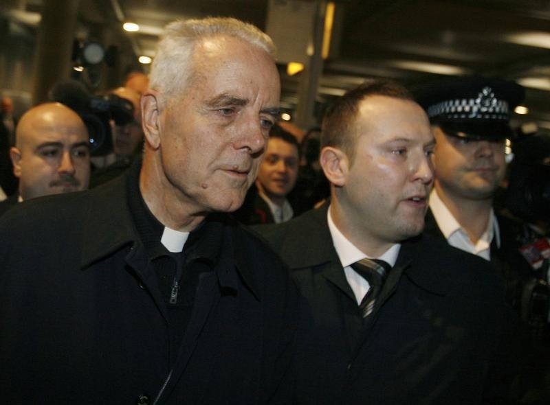 © Reuters. British-born Roman Catholic Bishop Richard Williamson is escorted by police on his arrival at Heathrow Airport in London