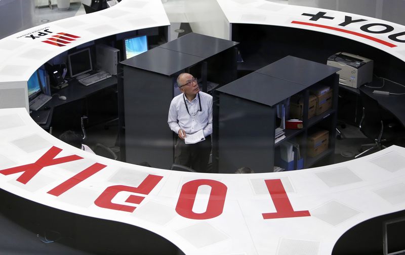 © Reuters. An employee of the Tokyo Stock Exchange looks at a stock quotation board as he works at the bourse at TSE in Tokyo