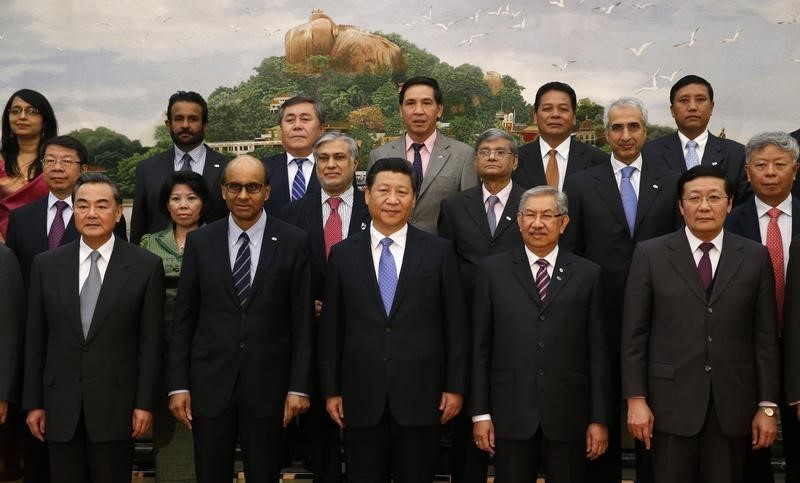 © Reuters. China's President Xi Jinping poses for photos with guests at the Asian Infrastructure Investment Bank launch ceremony at the Great Hall of the People in Beijing