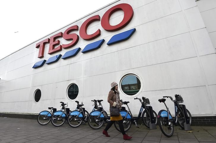 © Reuters. Woman walks past a Tesco supermarket in central London