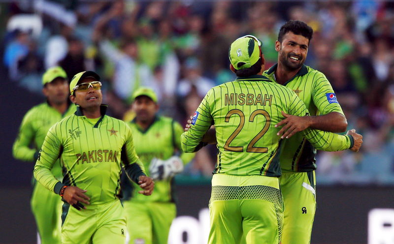 © Reuters. Pakistan bowler Sohail Khan hugs captain Misbah ul Haq after Australia's batsman Aaron Finch was given out LBW during their Cricket World Cup quarter final match in Adelaide