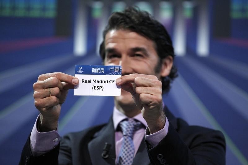 © Reuters. UEFA Champions League Ambassador Riedle shows the name of Real Madrid during the Champions League quarter-final draw at the UEFA headquarters in Nyon