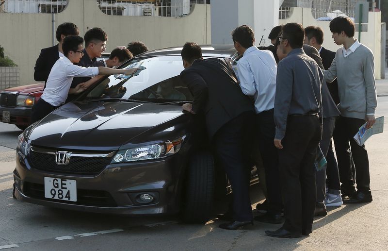 © Reuters. Property sales agents stop a car as they approach a potential client outside a model flat in Hong Kong