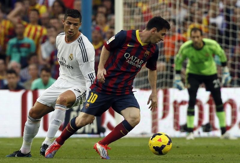 © Reuters. Barcelona's Messi is chased by Real Madrid's Ronaldo during their Spanish first division "Clasico" soccer match at Nou Camp stadium in Barcelona