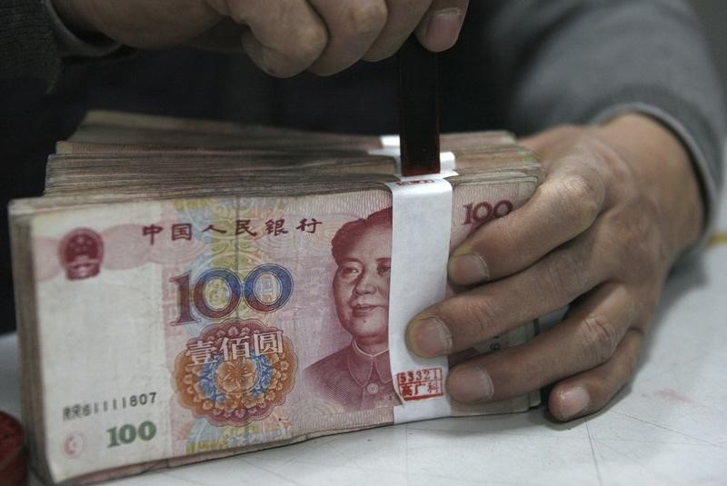 © Reuters. An employee seals a stack of yuan banknotes at a branch of Industrial and Commercial Bank of China in Huaibei