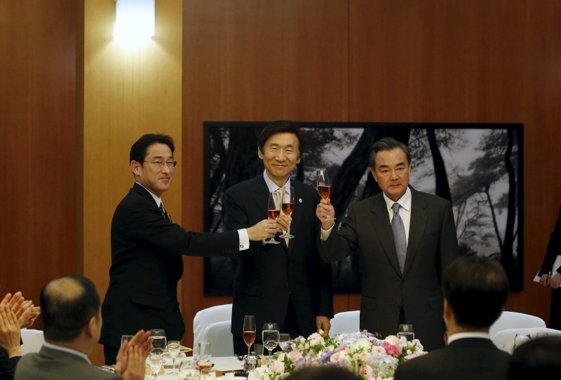 © Reuters. Japanese Foreign Minister Kishida, South Korean Foreign Minister Yun and Chinese Foreign Minister Wang make a toast during a banquet at the South Korean Foreign Minister's residence in Seoul